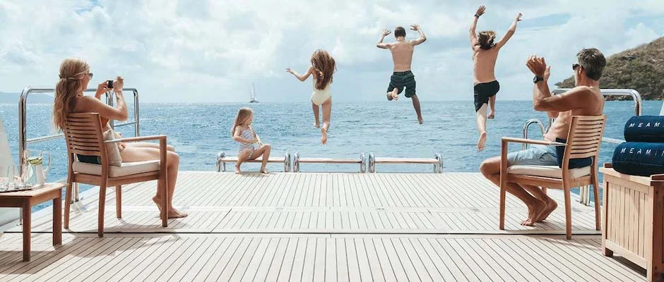 Kids jumping into water from yacht